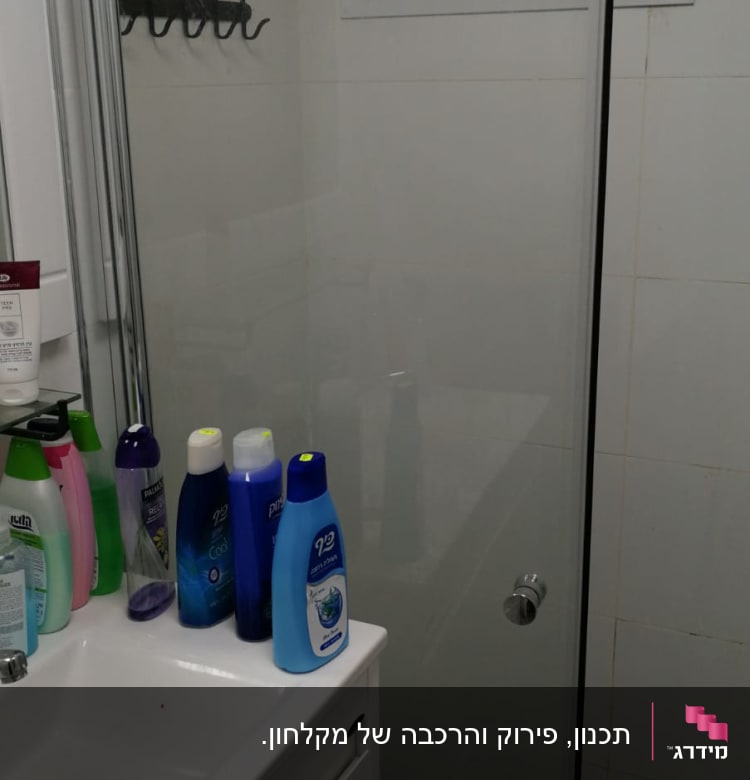 מקלחון זכוכית עם ידית מתכת בחדר אמבטיה